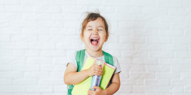 child smiling wearing backpack