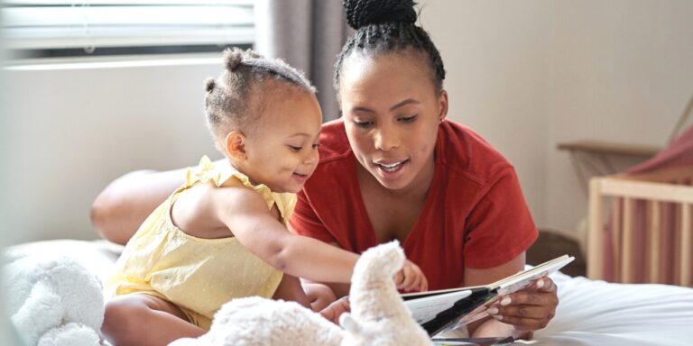 mom and toddler girl reading books together