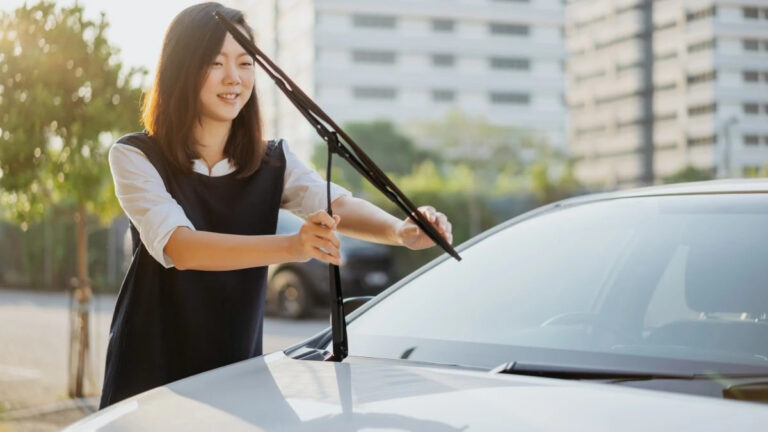 young asian woman checking windshield wiper