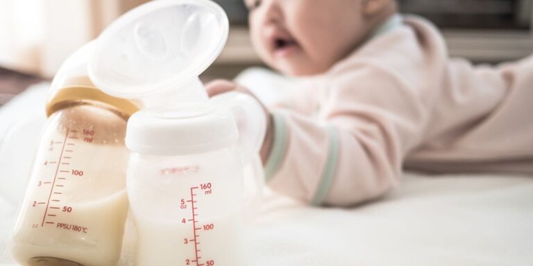 baby next to pumped breast milk donating breast milk