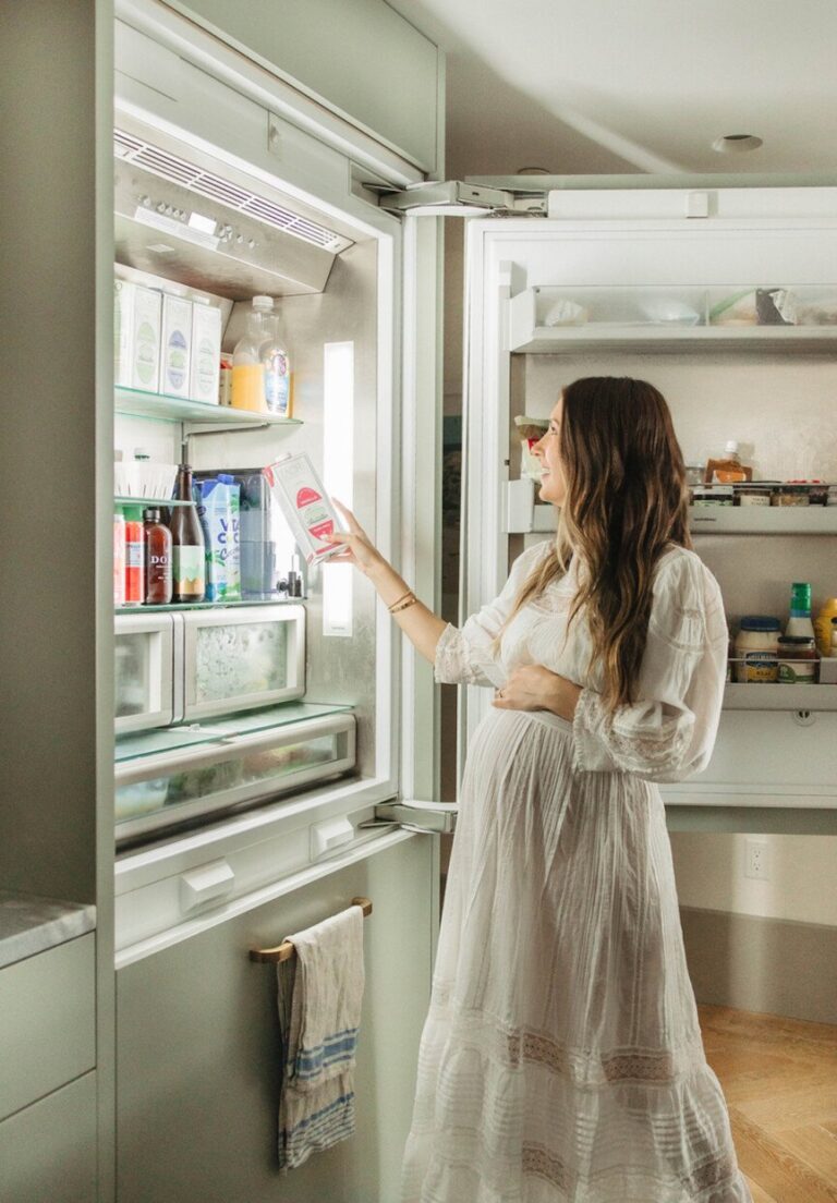 woman reaching into fridge 865x1243